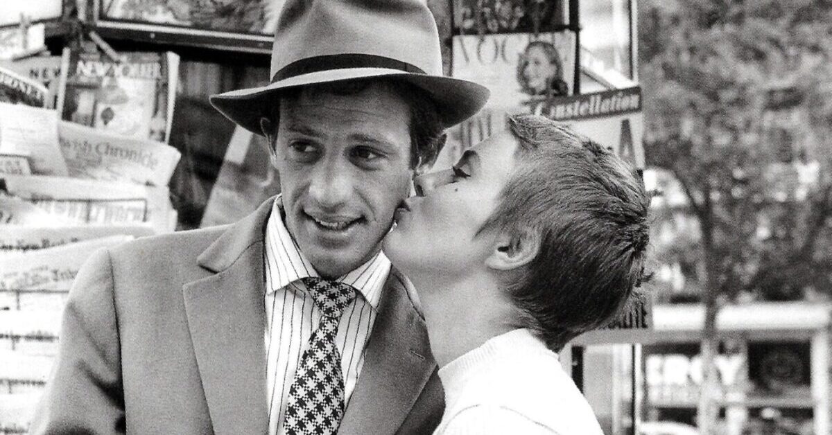 A woman kisses a man on the cheek in black and white